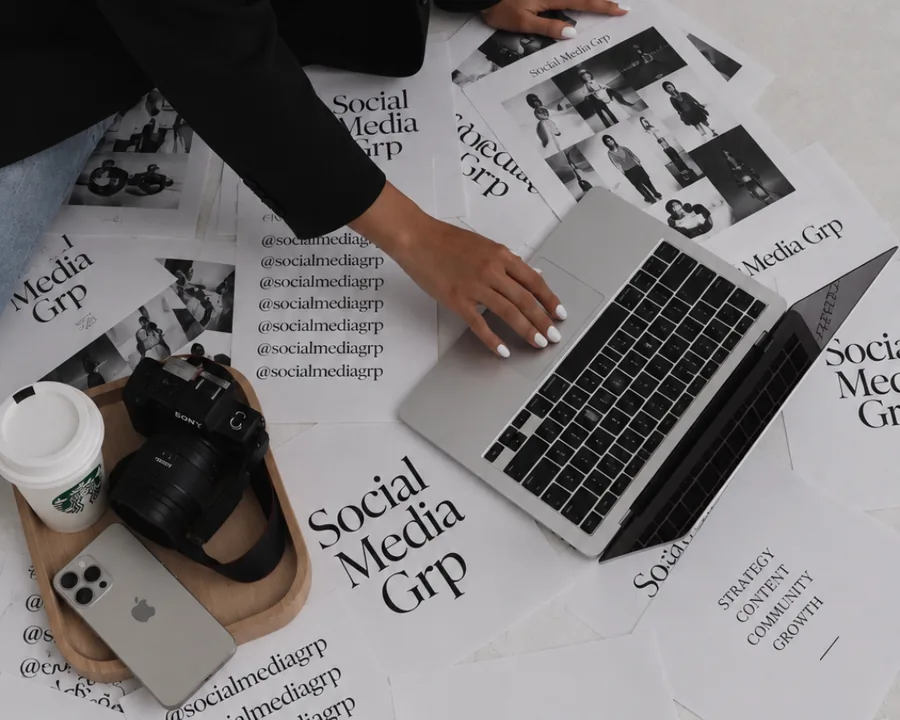 Flatlay aus dem Studio: gedruckte SocialMediaGRP-Zeitungen, Laptop, Kamera, Smartphone und Kaffee
